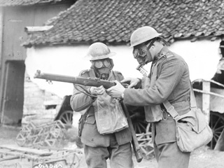 Two Soldiers Wearing Gas Masks Examining a Lee Enfield Rifle, France, March 1917.