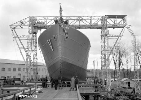 The photo shows the corvette HMCS La Malbaie under the scaffolding of a mobile crane just before being inaugurated at the shipyard of Marine Industries Ltd., Sorel, Quebec, October 25, 1941.