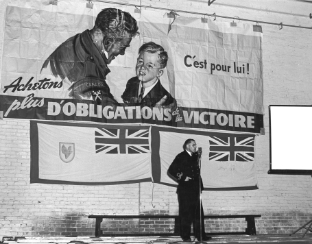 In this photo, an officer of the Royal Canadian Navy Volunteer Reserve speaks to factory workers at the Canadian International Paper mill in Gatineau, Quebec, before a screening of NFB films for the industrial circuit, May 1945.