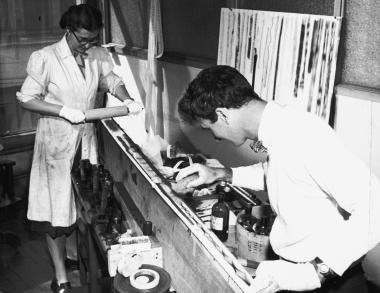 Norman McLaren moistens the film on which the India ink drawings have been done.