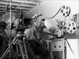 Norman McLaren uses a Moviola editing machine to coordinate the sound and images.