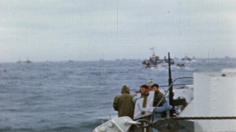 Colour footage : Men preparing and lowering detonator wire to blow up obstacle, shots of Canadian Army men on deck on crossing (06/06/1944 or 07/06/1944).