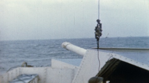 Colour footage : LS of rockets being fired as Royal Canadian Navy and allied ships blast the French coast from channel positions. Shots of deck gun on destroyer firing, LS of flashes of guns on horizon, RT officer instructing gun crew as to position etc. (06/06/1944 or 07/06/1944).