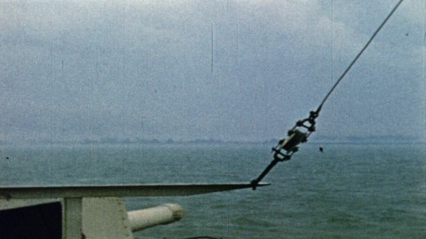 Colour footage : Sequence showing rockets being fired from ships lined up offshore. Flashes light the sky as rockets go off in sequence of fours (06/06/1944 or 07/06/1944).
