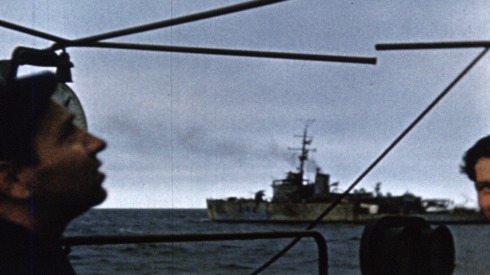 Colour footage : Shot of ships underway in the English Channel, of Royal Canadian Navy rating using signal lamp (06/06/1944 or 07/06/1944).