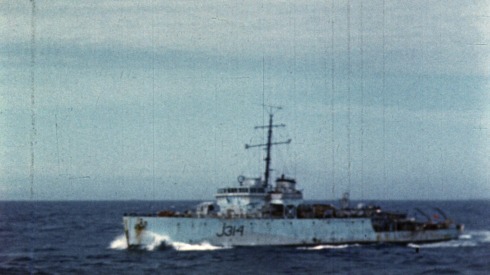 Colour footage : Swish PAN to HMCS Blairmore (J-314) a fleet minesweeper at sea. Side view of HMCS Blairmore at sea (06/06/1944 or 07/06/1944).